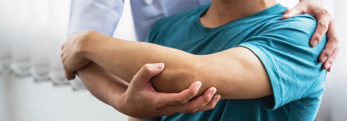 Patient receiving elbow mobility assessment and manual therapy treatment for elbow pain